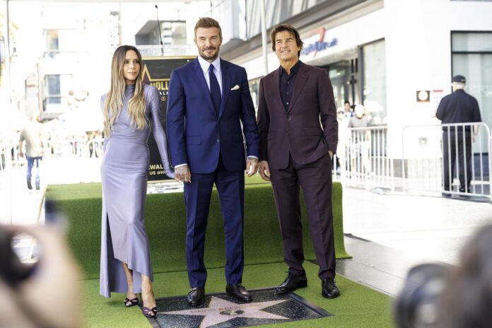 El exfutbolista británico David Beckham (c) fue captado, este 12 de junio, al posar junto a su esposa, la cantante Victoria Beckham (I), y el actor estadounidense Tom Cruise (2), durante una ceremonia en la que fue distinguido con una estrella en el Paseo de la Fama de Hollywood, en Los Ángeles (CA, EE.UU.). EFE/Ted Soqui
