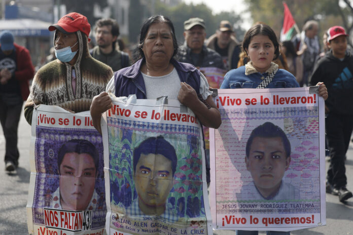 Personas caminan sosteniendo carteles con fotografías durante una manifestación, en Ciudad de México (México). EFE/ Sáshenka Gutiérrez
