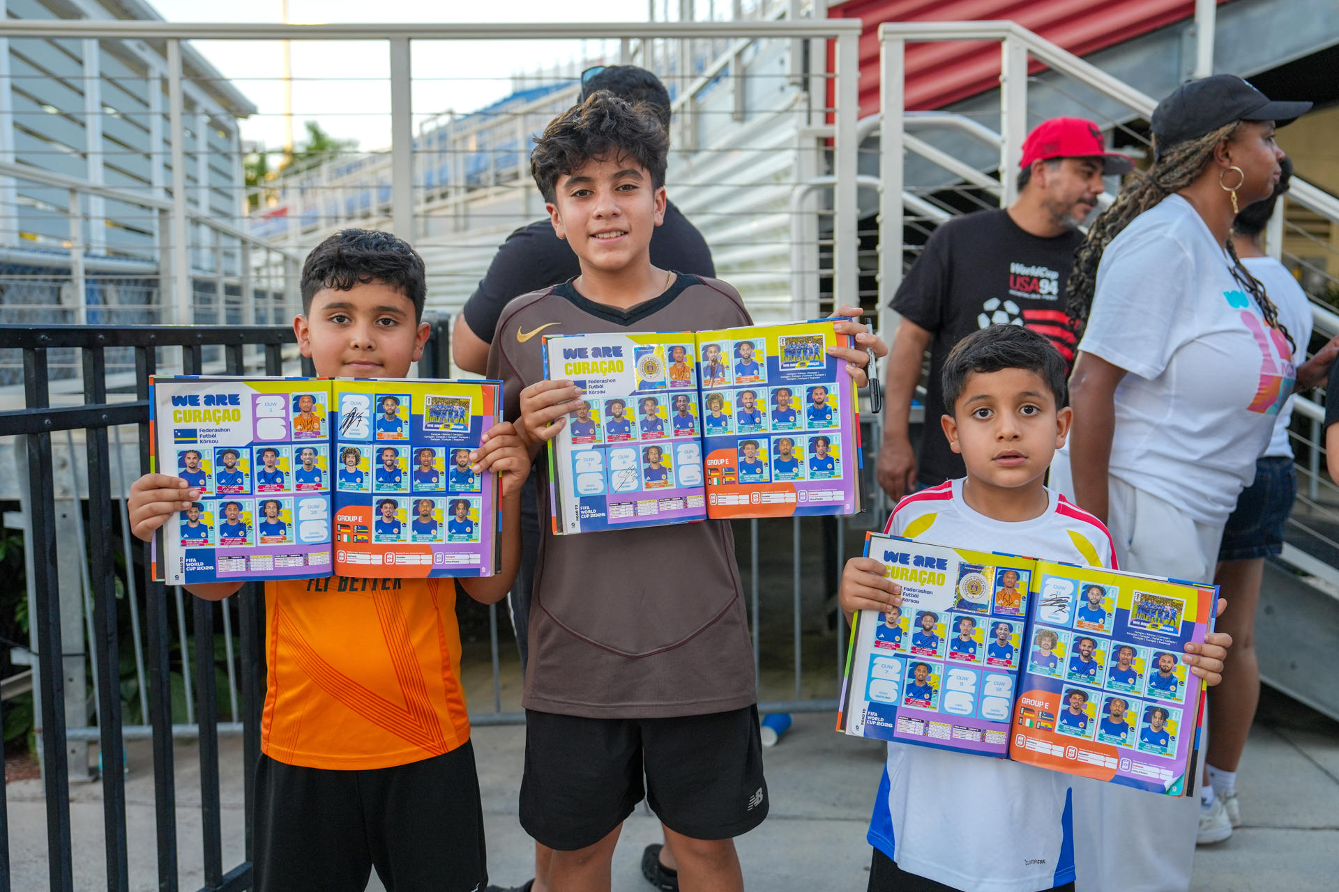 Jóvenes aficionados muestran álbumes con laminas de los integrantes de la selección de Curazao durante un entrenamiento en Boca Ratón (EE.UU.). EFE/Alberto Boal
