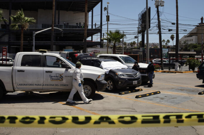 Integrantes de la Policía de México custodian la zona de un crimen este sábado, en Tijuana (México). EFE/Joebeth Terríquez

