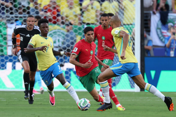 Vinicius Junior (i), de Brasil, disputa el balón con Achraf Hakimi (c), de Marruecos, este sábado durante un partido del Grupo C del Mundial 2026. EFE/ Sebastiao Moreira
