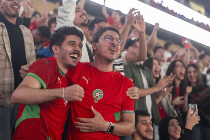Miles de hinchas de Marruecos reunidos este sábado en el Estadio Moulay Hassan de Rabat siguen con expectación el partido inaugural del Grupo C del Mundial contra Brasil jugado en la ciudad estadounidense de Newark y que terminó igualado 1-1. EFE/EPA/JALAL MORCHIDI

