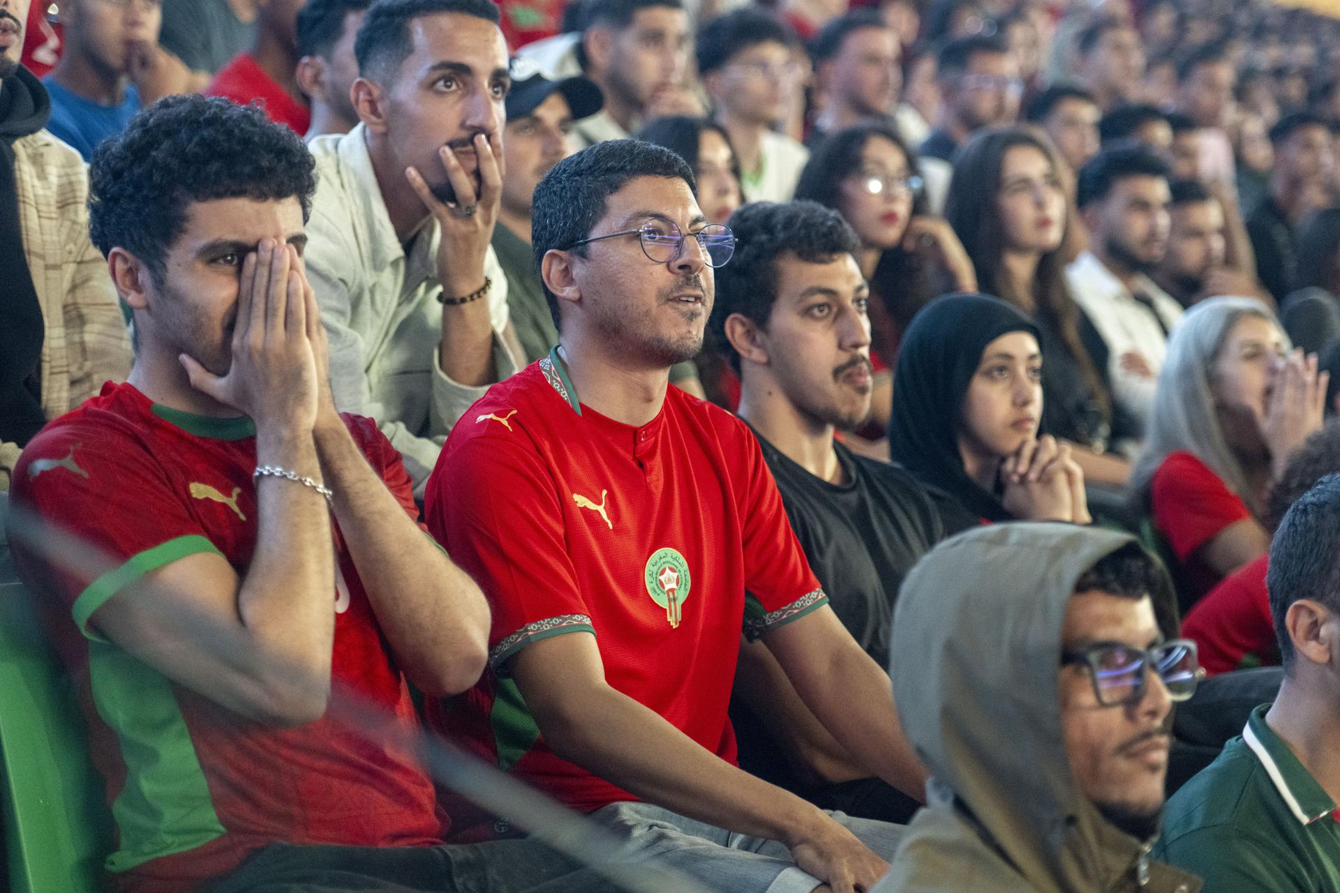 Miles de hinchas de Marruecos reunidos este sábado en el Estadio Moulay Hassan de Rabat siguen el partido inaugural del Grupo C del Mundial contra Brasil jugado en la ciudad estadounidense de Newark y que terminó igualado 1-1. EFE/EPA/JALAL MORCHIDI

