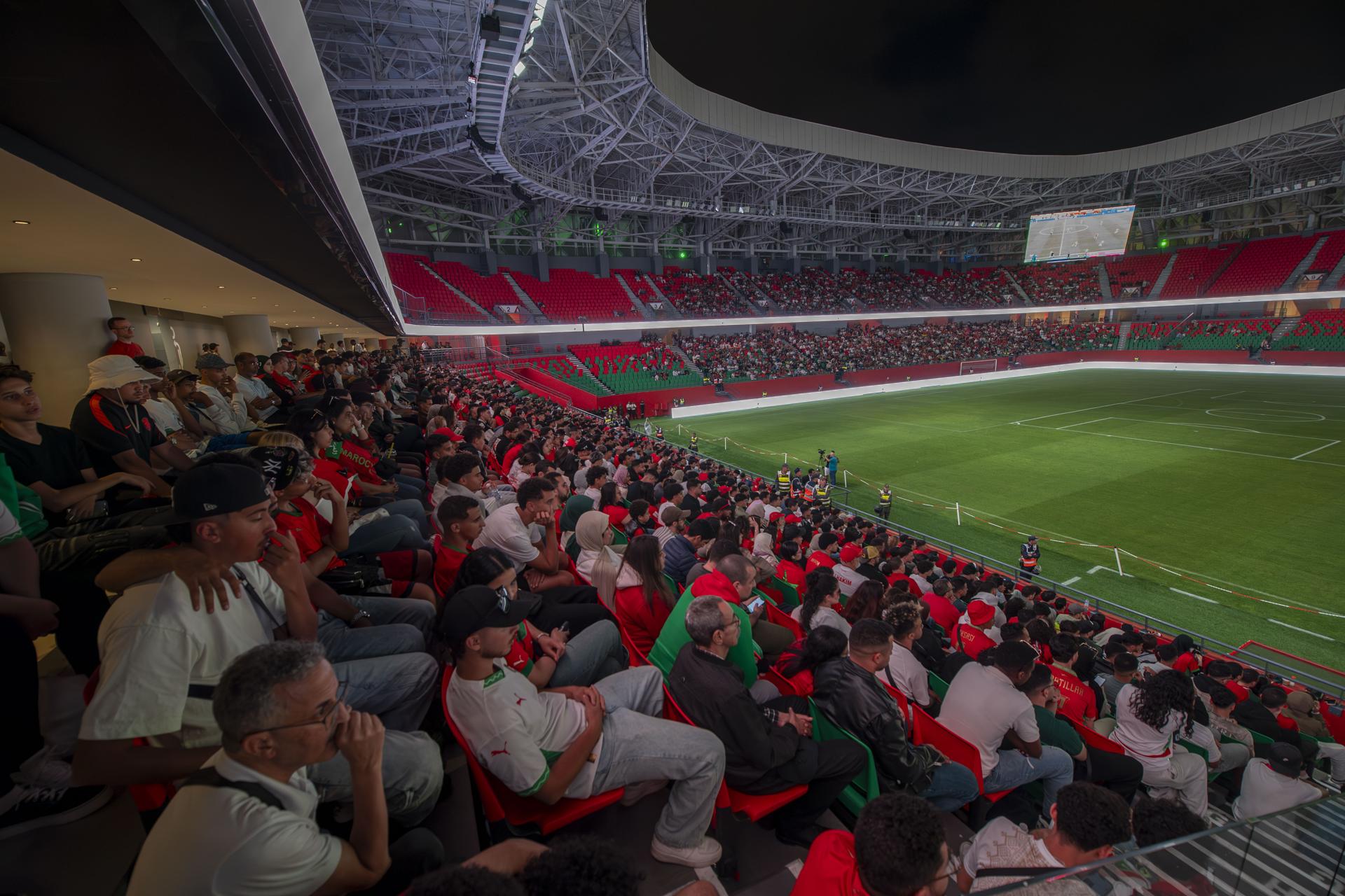 Hinchas de Marruecos reunidos este sábado en el Estadio Moulay Hassan de Rabat siguen el partido inaugural del Grupo C del Mundial contra Brasil jugado en la ciudad estadounidense de Newark y que terminó igualado 1-1. EFE/EPA/JALAL MORCHIDI
