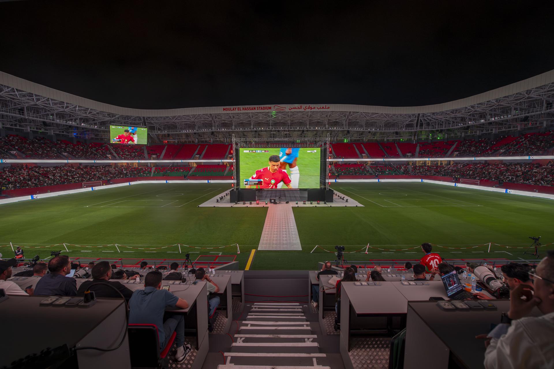 Hinchas de Marruecos reunidos este sábado en el Estadio Moulay Hassan de Rabat siguen el partido inaugural del Grupo C del Mundial contra Brasil jugado en la ciudad estadounidense de Newark y que terminó igualado 1-1. EFE/EPA/JALAL MORCHIDI
