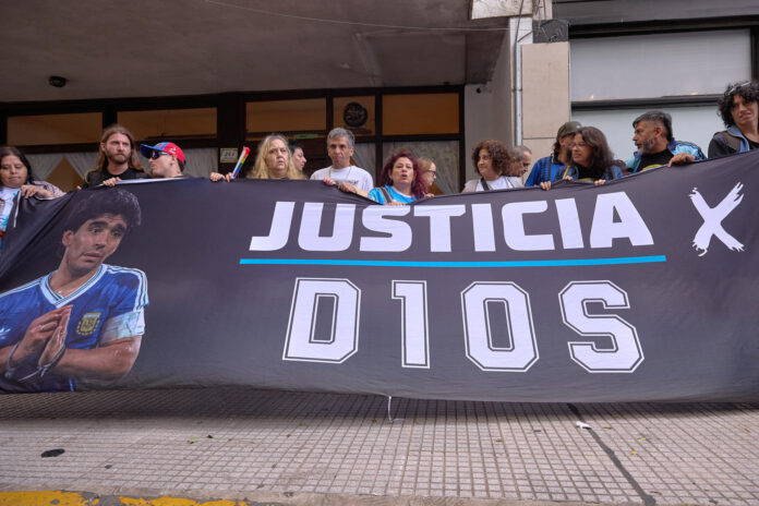 Fotografía de archivo, tomada el pasado 14 de abril, en la que se captó a un grupo de simpatizantes de Diego Armando Maradona al exigir justicia durante el inicio del segundo juicio por la muerte del legendario futbolista argentino, a las afuera del tribunal de San Isidro, en Buenos Aires (Argentina). EFE/Adán González
