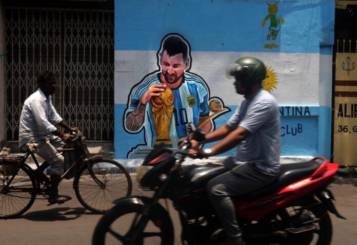 Calcuta (India), 12/06/2026.- Transeúntes indios pasan cerca de un mural callejero que representa a Lionel Messi de Argentina en Calcuta, India, el 12 de junio de 2026. 
EFE/EPA/PIYAL ADHIKARY
