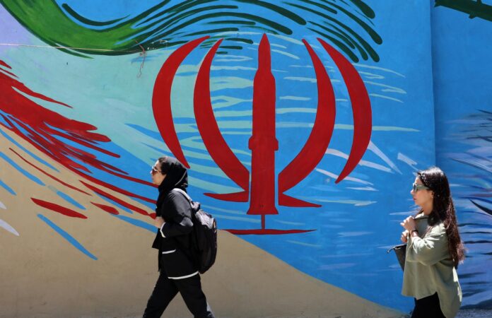 - Ciudadanos iraníes pasan junto a un mural con la bandera nacional de Irán en una calle de Teherán, Irán, este lunes. El presidente estadounidense Donald Trump anunció en sus redes sociales que se ha alcanzado un acuerdo con Irán, el cual se firmará el 19 de junio en Suiza. (Suiza, Teherán) EFE/EPA/ABEDIN TAHERKENAREH RESTRICCIONES: Prohibido el acceso a medios de comunicación israelíes/canales de televisión en persa fuera de Irán/Prohibido el acceso a BBC Persian/VOA Persian/Manoto TV/Televisión Internacional de Irán. (Según lo dispuesto por la Dirección General de Medios de Comunicación Extranjeros de Irán)
