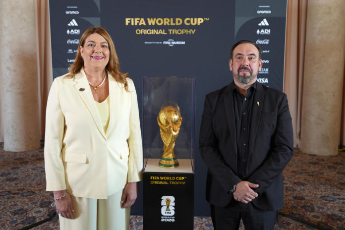 La presidenta del Miami-Dade College (MDC), Madeline Pumariega (i) y el director del Museo de la FIFA, Marco Fazzone, posan junto a la Copa del Mundo FIFA este lunes, en Miami (Estados Unidos). La copa original del Mundial de la FIFA se exhibe de forma gratuita en la Torre de la Libertad (Freedom Tower) de Miami, que acoge ahora su primer partido del torneo, el de Arabia Saudí contra Uruguay, país latinoamericano que tiene su mayor comunidad en EE.UU. EFE/ Alberto Boal

