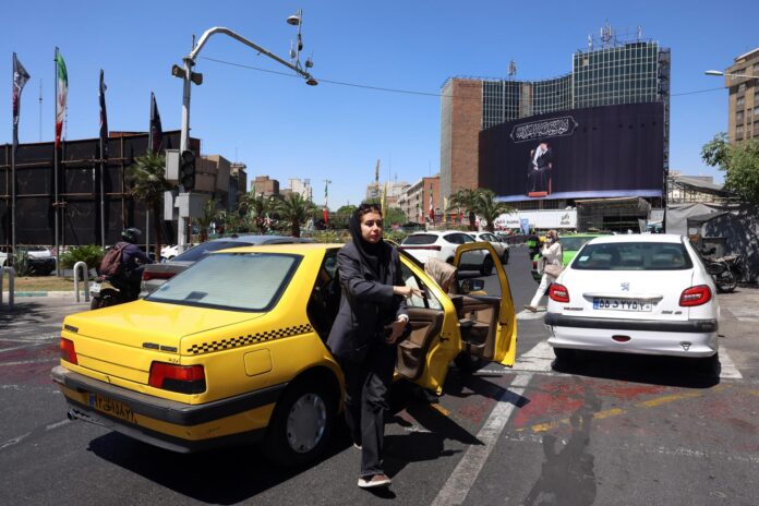 .- Una mujer iraní baja de un taxi en la plaza Valiasr de Teherán, Irán, el 15 de junio de 2026. El presidente de Estados Unidos, Donald Trump, anunció en su plataforma de redes sociales que se ha alcanzado un acuerdo con Irán y que se firmará el 19 de junio en Suiza. (Suiza, Teherán) EFE/EPA/ABEDIN TAHERKENAREH RESTRICCIONES: SIN acceso a medios de Israel/Cadenas de televisión en persa fuera de Irán/Estrictamente SIN acceso a BBC Persian/VOA Persian/Manoto TV/Iran International TV. (Según lo ordenado por la Dirección General de Medios Extranjeros de Irán) --
