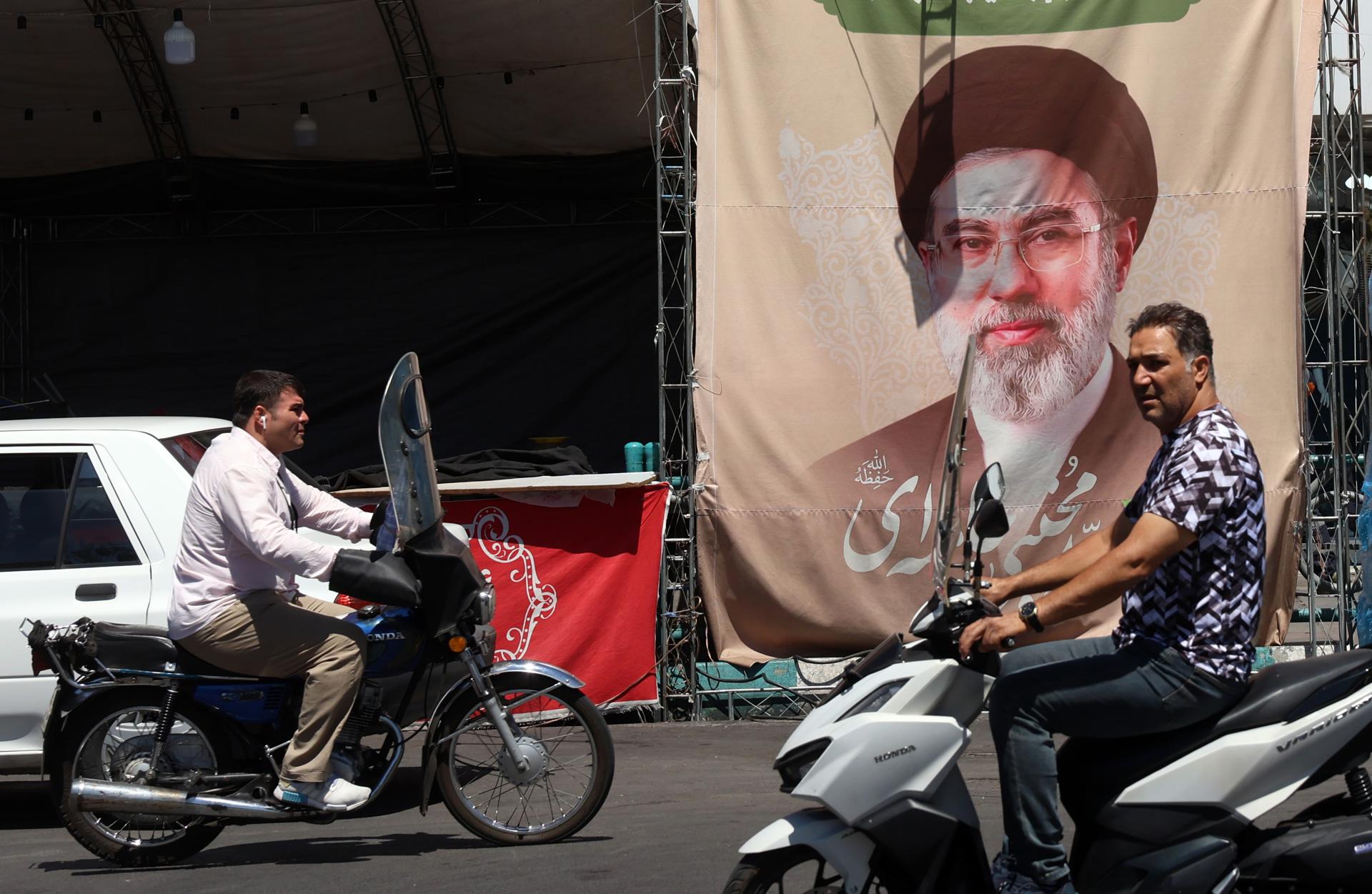 - Los iraníes pasan en coche frente a una valla publicitaria del líder supremo iraní, el ayatolá Mojtaba Jamenei, en la plaza Valiasr de Teherán, Irán, el 15 de junio de 2026. El presidente de Estados Unidos, Donald Trump, anunció en su plataforma de redes sociales que se ha llegado a un acuerdo con Irán y que se firmará el 19 de junio en Suiza. (Suiza, Teherán) EFE/EPA/ABEDIN TAHERKENAREH RESTRICCIONES: NO acceso a medios israelíes/canales de televisión en idioma persa fuera de Irán/estrictamente NO acceso a BBC Persian/VOA Persian/Manoto TV/Iran International TV. (Según lo ordenado por la Dirección General de Medios Extranjeros de Irán) --
