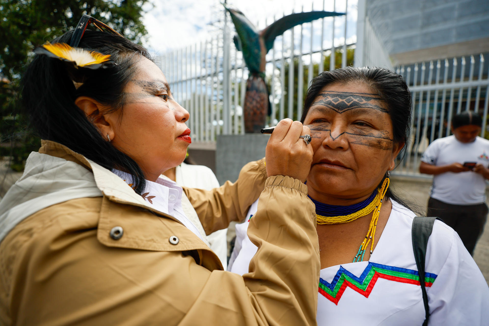 Indígenas de la comunidad Sarayaku se pintan el rostro este lunes, afuera de la Asamblea Nacional en Quito (Ecuador). EFE/ José Jácome
