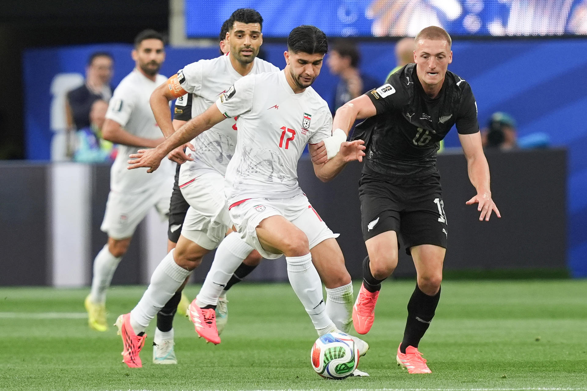 Arya Yousefi (c), de Irán, disputa el balón con Finn Surman (d), de Nueva Zelanda, en partido del Mundial 2026 en el estadio SoFi en Los Ángeles (Estados Unidos). EFE/Omar Alonso
