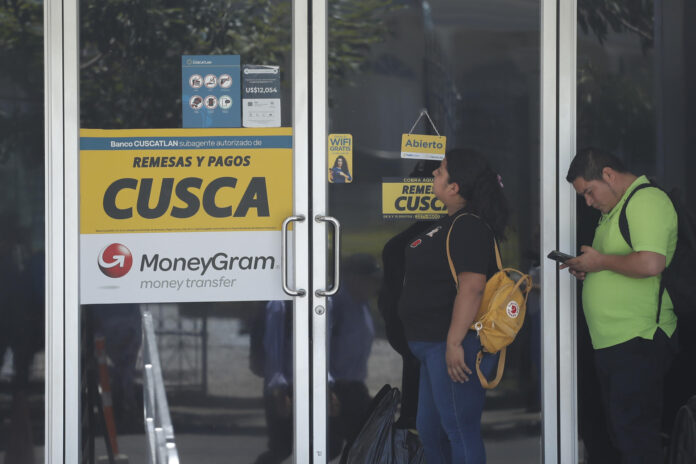 Un grupo de personas fue captado este 15 de junio al hacer fila para ingresar a una agencia de giros de remesas, en San Salvador (El Salvador). EFE/Rodrigo Sura
