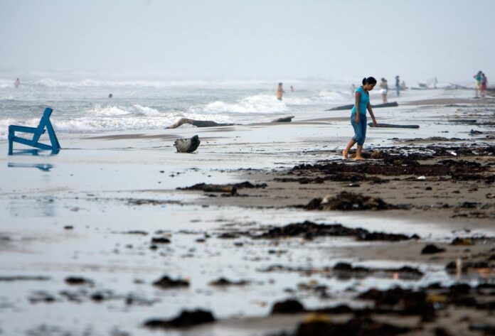 Turistas nacionales se aventuran a adentrase en el mar picado en la Playa Bagdad, 38 kilómetros al este de Matamoros, estado de Tamaulipas (México). EFE/David de la Paz
