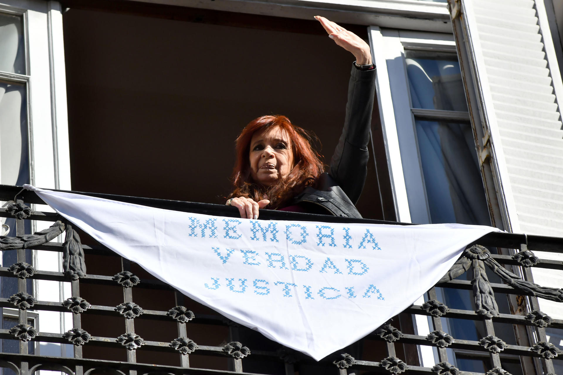 AME1669. BUENOS AIRES (ARGENTINA), 16/06/2026.- La expresidenta Cristina Fernández (2007-2015) reacciona desde un balcón durante el cortejo fúnebre de Taty Almeida, en su camino al cementerio este martes, en Buenos Aires (Argentina). Fernández salió al balcón a despedirse de Almeida, con quien mantenía un vínculo muy cercano, colgando sobre las rejas el tradicional pañuelo de las Madres de Plaza de Mayo con la inscripción 'Memoria, Verdad y Justicia'. EFE/ Enrique García Medina