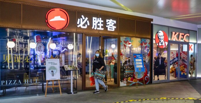 Imagen de archivo de una mujer frente a los restaurantes Pizza Hut y KFC operados por Yum China en Shanghái, China, el 11 de septiembre de 2020. 
EFE/EPA/ALEX PLAVEVSKI

