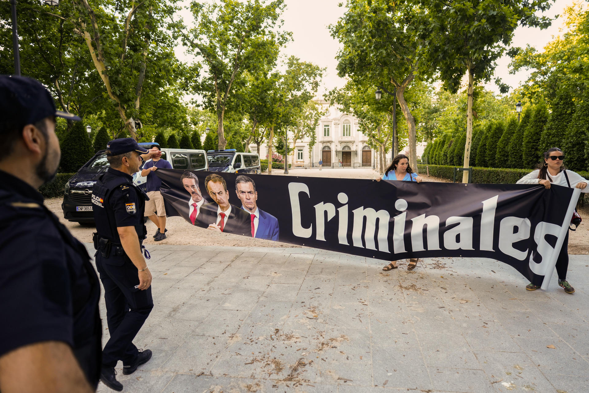 Tres personas sostienen un cartel en el entorno de la Audiencia Nacional, donde el expresidente del Gobierno José Luis Rodríguez Zapatero declara este miércoles como investigado por organización criminal, tráfico de influencias y falsedad en la causa sobre el préstamo a la compañía aérea Plus Ultra. EFE/ Borja Sanchez-Trillo
