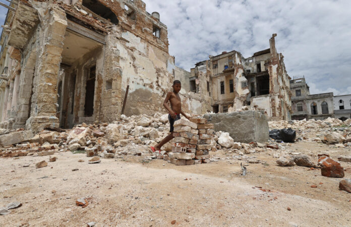 Un niño carga ladrillos de un edificio destruido en el malecón habanero el 11 de junio de 2026, en La Habana (Cuba). EFE/ Ernesto Mastrascusa
