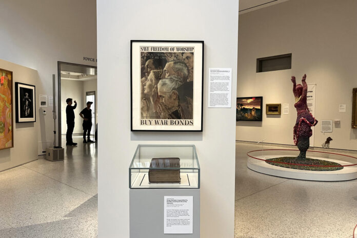 Fotografía que muestra una imagen de la Segunda Guerra Mundial de Norman Rockwell con el mensaje 'Save Freedom of Worship. Buy War Bonds' (Salve la libertad de culto. Compre bonos de guerra) durante la exposición 'Democracy Matters' este martes, en el museo New York Historical de Nueva York (Estados Unidos). EFE/ Nora Quintanilla
