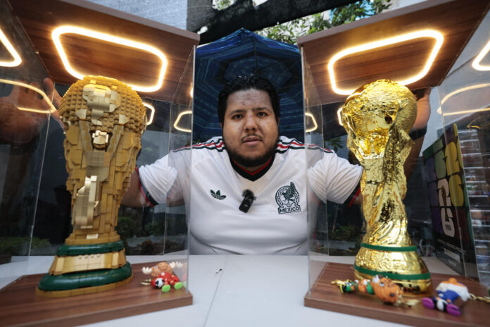 El coleccionista de objetos mundialistas José Luis Herrera posa junto a replicas del trofeo de la Copa Mundial de la FIFA este martes, en Ciudad de México (México). EFE/José Méndez
