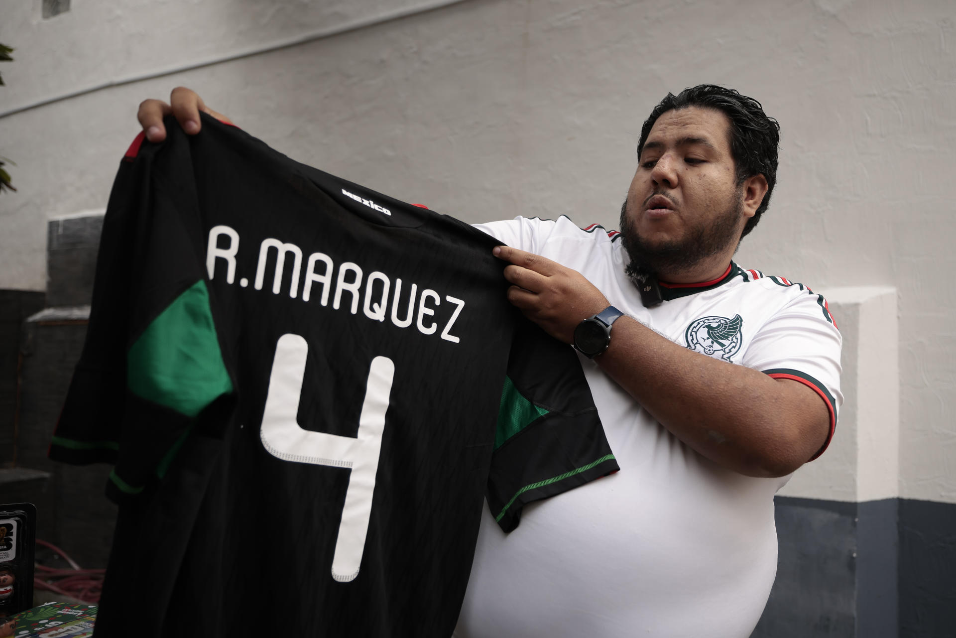 El coleccionista de objetos mundialistas José Luis Herrera muestra una playera del exseleccionador mexicano Rafael Márquez durante una entrevista con EFE este martes, en Ciudad de México (México). EFE/José Méndez