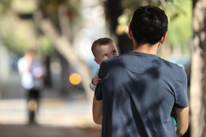 Un bebé observa a su padre mientras ambos pasean en una imagen de archivo. EFE/Alberto Valdés
