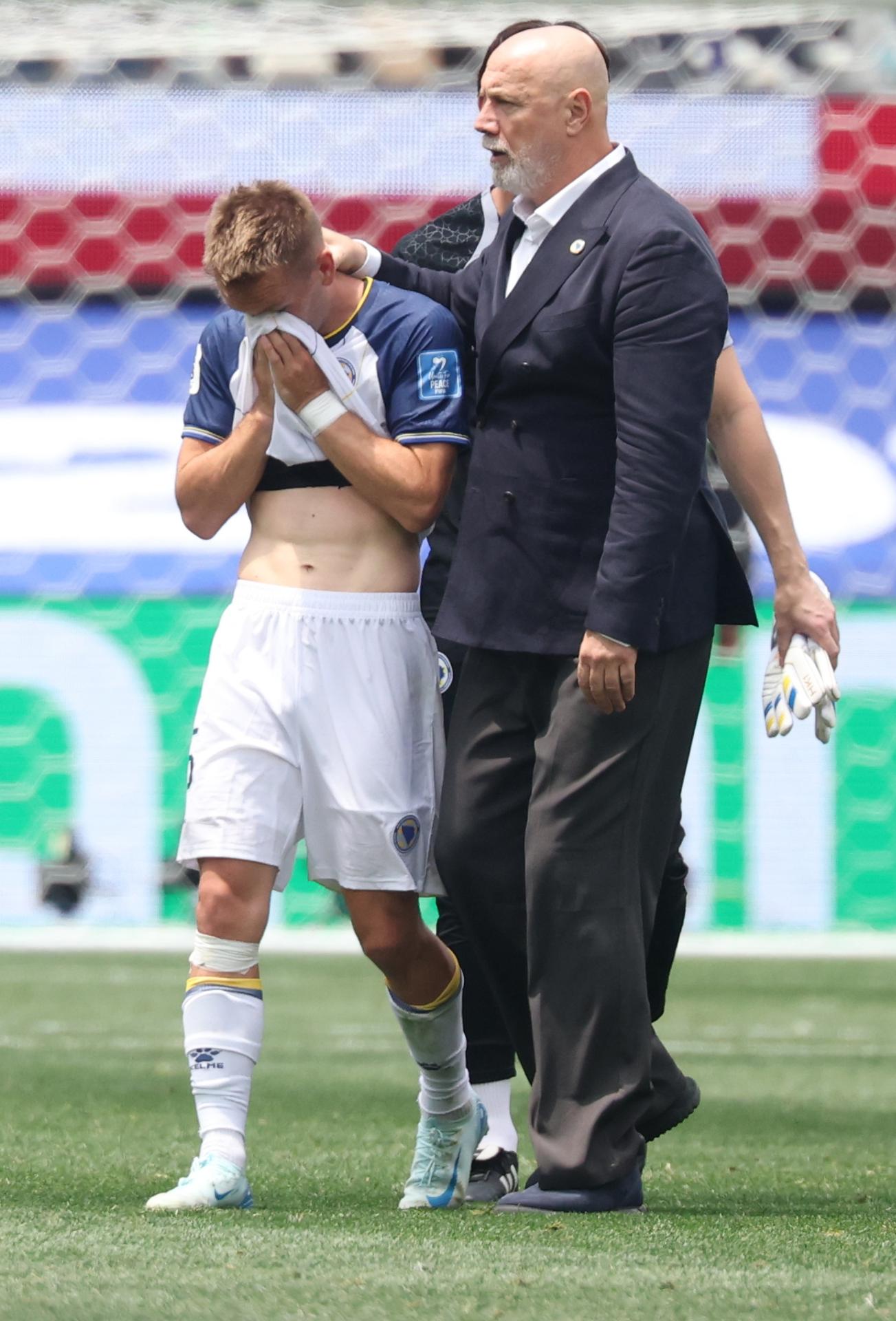 Amar Memic, de Bosnia y Herzegovina (d), es consolado por el seleccionador nacional, Sergej Barbarez, tras la derrota en el partido de la fase de grupos del Mundial de Fútbol 2026 ante Suiza, en Los Ángeles (EE.UU.). EFE/CRISTOPHER TORRES
