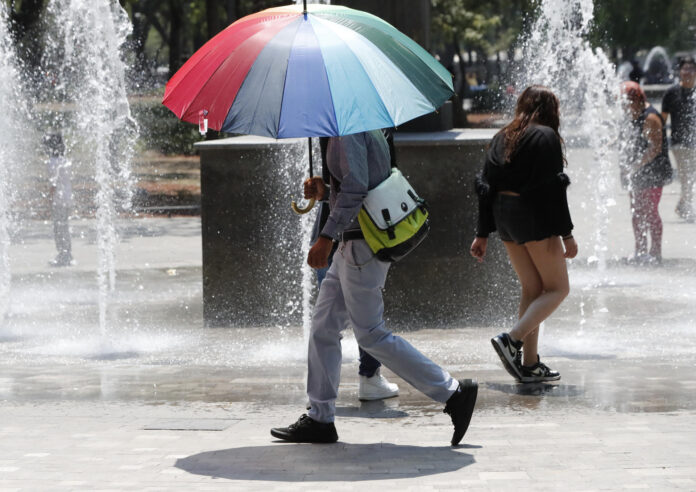 Una persona utiliza una sombrilla para protegerse del sol durante un día caluroso, en Ciudad de México (México). Imagen de archivo. EFE/ Mario Guzmán

