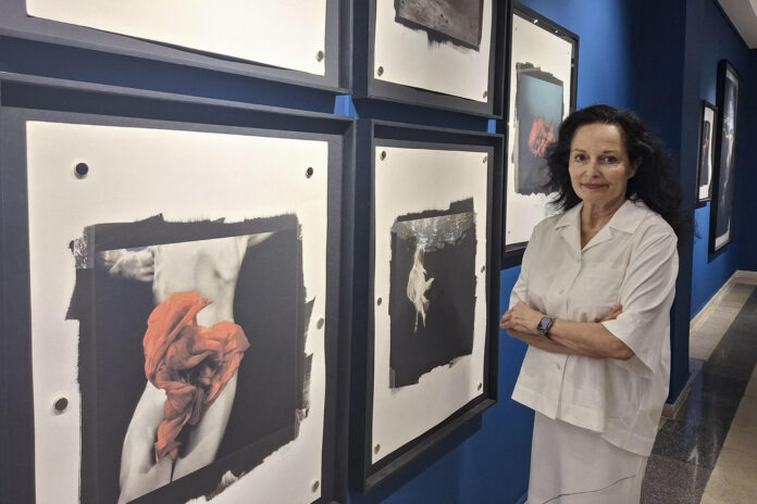 La fotógrafa Isabel Muñoz posa, durante una entrevista con EFE en la Galería Cervantes del Instituto Cervantes de Tánger, ante obras de la exposición 'El agua que somos', propuesta estrella de Photo Tánger, primer festival internacional de fotografía de esta ciudad marroquí, con España como país invitado. EFE/ Mar Marín
