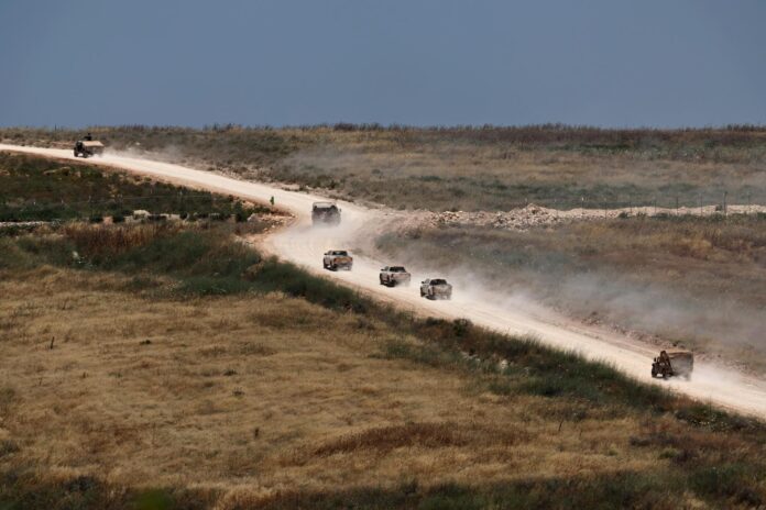 Vehículos militares se desplazan por el sur del Líbano, vistos desde el lado israelí de la frontera en la Alta Galilea, al norte de Israel. EFE/EPA/ATEF SAFADI
