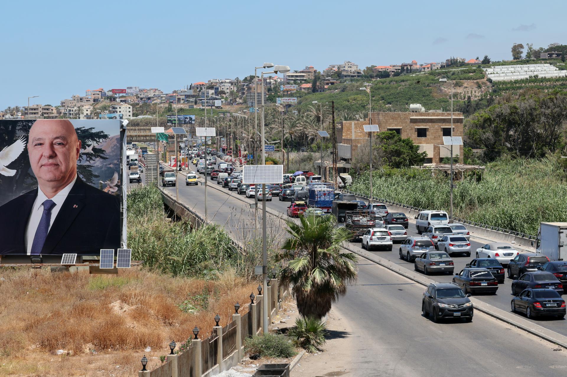 Se ve un cartel con el presidente libanés Joseph Aoun mientras los libaneses huyen con sus pertenencias por la autopista de Sidón hacia Beirut tras los bombardeos israelíes que afectaron a pueblos del sur del Líbano, 19 de junio de 2026. Según el Ministerio de Salud del Líbano, hasta el 19 de junio, los ataques israelíes en todo el Líbano han causado más de 3.930 muertos y más de 11.900 heridos desde que se reanudaron las hostilidades entre Israel y Hezbolá el 2 de marzo de 2026. (Líbano, Hizbulá/Hezbolá) EFE/EPA/WAEL HAMZEH