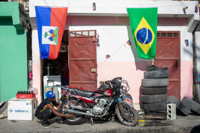 Una persona limpia una motocicleta en Puerto Príncipe (Haití). EFE/ Jonet St Élois
