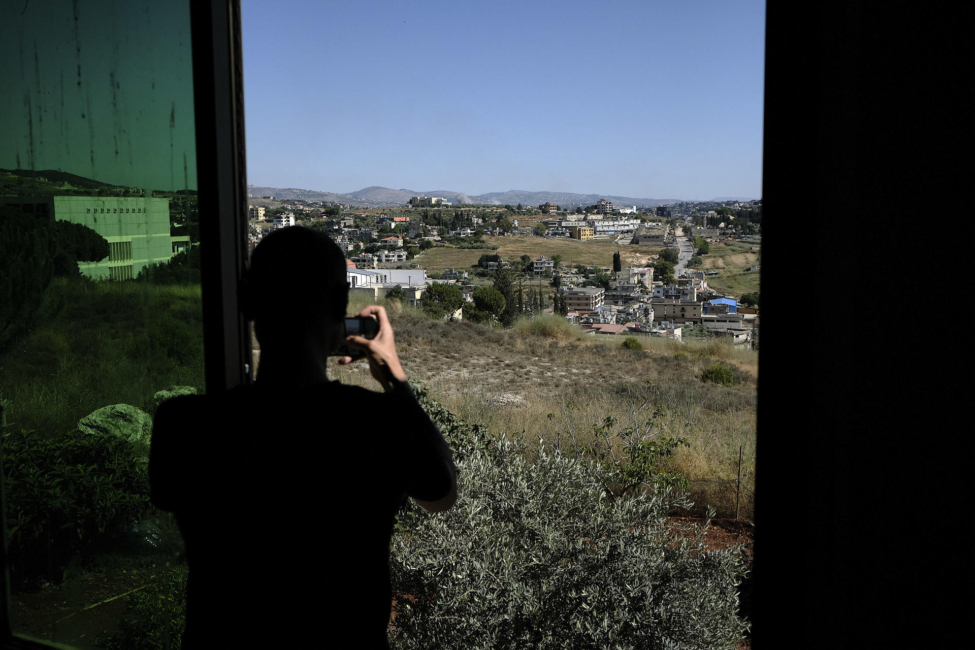 .- Un paramédico de la organización Ambulancias Nabatieh observa este viernes un bombardeo israelí sobre la ciudad de Nabatieh, sur de Líbano. EFE / Edgar Gutiérrez.