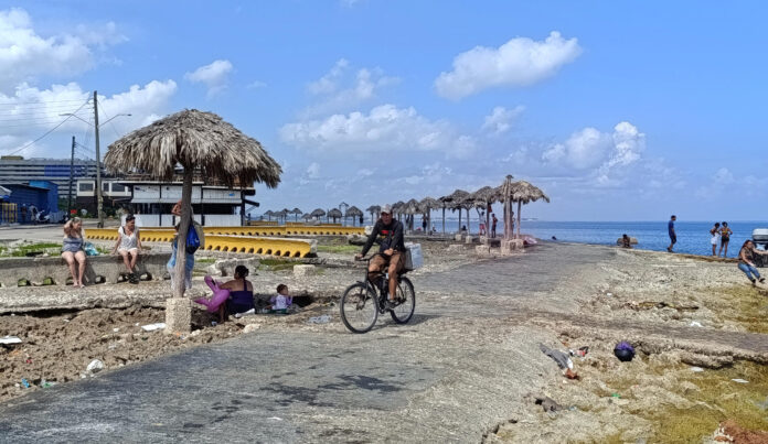 Una persona transita en bicicleta frente al mar este viernes, en La Habana (Cuba). EFE/ Ernesto Mastrascusa
