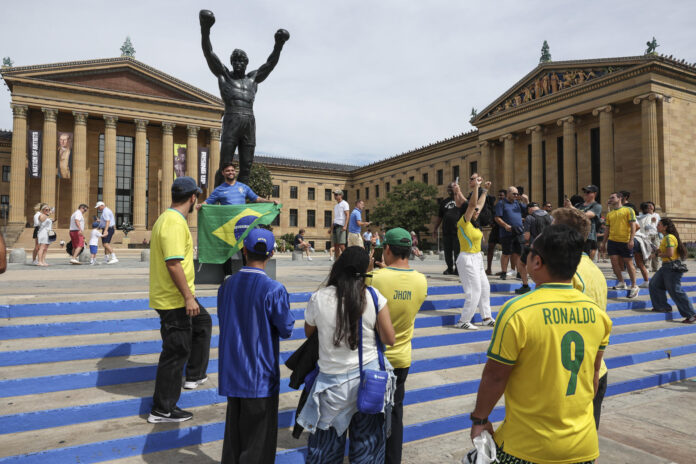 Los aficionados de la selección brasileña de fútbol visitan la estatua del boxeador Rocky Balboa en el centro de Filadelfia (EE.UU.), inspirada en el personaje interpretado por Sylvester Stallone en las películas. EFE/SEBASTIÃO MOREIRA

