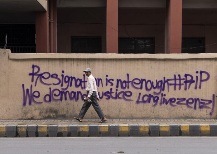 Una persona camina frente a un muro con un mensaje de los manifestantes en Katmandú, Nepal, el 10 de septiembre de 2025, tras protestas lideradas por la llamada Generación Z, que destruyeron edificios gubernamentales importantes, incluyendo el Parlamento y la secretaría del gobierno, Singha Durbar. EFE/EPA/NARENDRA SHRESTHA
