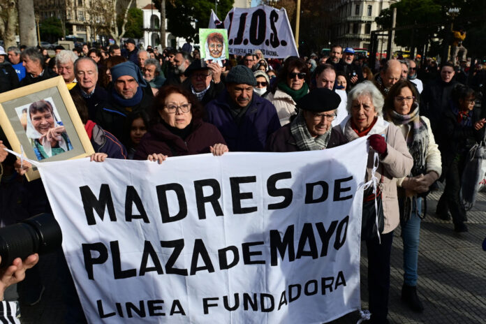 Familiares de Taty Almeida, referente de las Madres de Plaza de Mayo fallecida el pasado domingo, y el activista por los derechos humanos Adolfo Pérez Esquivel (3-d), Premio Nobel de la Paz 1980, sostienen un cartel de Madres de Plaza de Mayo Línea Fundadora durante la diseminación de las cenizas de Taty, este sábado en la Plaza de Mayo en Buenos Aires (Argentina). EFE/Matías Martín Campaya
