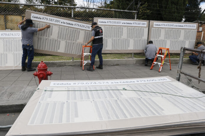 Personas preparan un puesto de votación este sábado, en el recinto ferial de Corferias en Bogotá (Colombia). EFE/ Carlos Ortega
