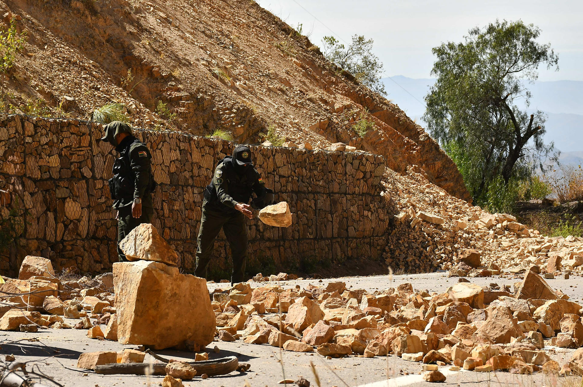 Integrantes de la Policía de Bolivia remueven rocas del suelo durante un operativo de desbloqueo del Ejercito y la Policía de Bolivia en Cochabamba (Bolivia). EFE/Jorge Abrego
