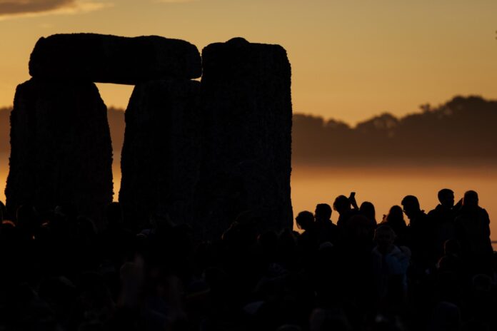 Decenas de miles de personas observan el amanecer durante las celebraciones del solsticio de verano en el antiguo monumento de Stonehenge en Wiltshire, Reino Unido, el 21 de junio de 2026. El solsticio de verano ocurre cuando uno de los polos de la Tierra tiene su máxima inclinación hacia el Sol. El festival anual en el círculo de piedras de 5.000 años atrae a multitudes para marcar el día más largo en el Hemisferio Norte. (Reino Unido) EFE/EPA/TOLGA AKMEN
