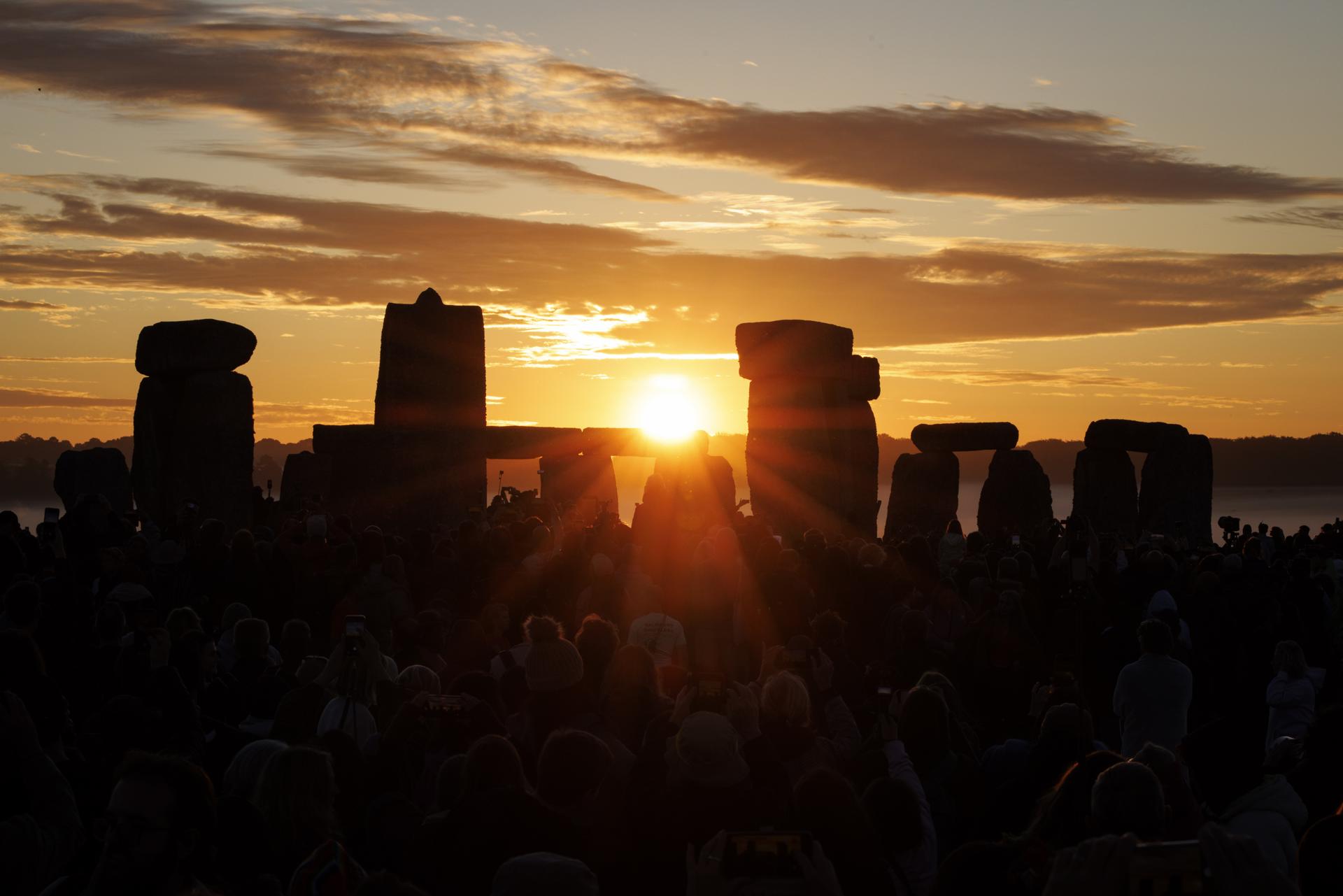 Decenas de miles de personas observan el amanecer durante las celebraciones del solsticio de verano en el antiguo monumento de Stonehenge en Wiltshire, Reino Unido, el 21 de junio de 2026. El solsticio de verano ocurre cuando uno de los polos de la Tierra tiene su máxima inclinación hacia el Sol. El festival anual en el círculo de piedras de 5.000 años atrae a multitudes para marcar el día más largo en el Hemisferio Norte. (Reino Unido) EFE/EPA/TOLGA AKMEN

