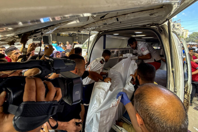 Los servicios de emergencia retiran el cuerpo de una adolescente que murió tras un ataque del Ejército israelí en ciudad de Gaza que además hirió a al menos cinco personas, según informaron fuentes médicas del enclave palestino. EFE/Ahmad Awad
