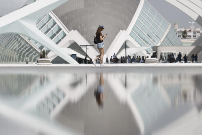 Una joven se refleja en el estanque de la Ciudad de las Artes y las Ciencias de Valencia este lunes. EFE/ Kai Försterling
