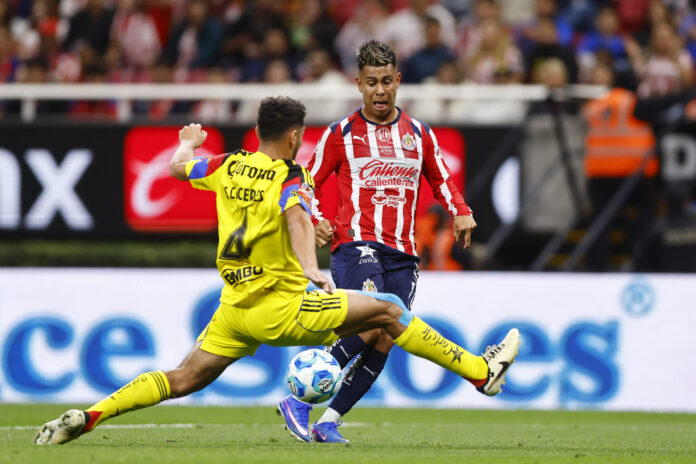 Fotografía de archivo del 14 de febrero de 2026 en la que se observa a Efraín Álvarez (d), de las Chivas de Guadalajara, al disputar el balón con Sebastián Cáceres, del América, en un partido de la Liga MX entre Guadalajara y América disputado en el Estadio Akron, en Guadalajara (México). EFE/Francisco Guasco
