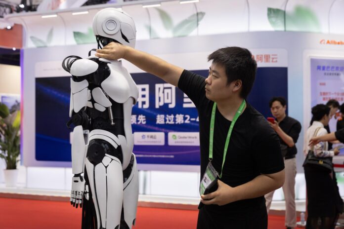 PEKÍN (China), 22/06/2026.- Un empleado ajusta un robot en la Exposición Internacional de la Cadena de Suministro de China en Pekín, China, el 22 de junio de 2026. 
EFE/EPA/JESSICA LEE
