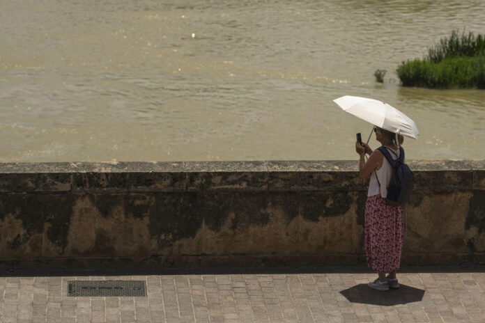 Una turista toma una foto del río Guadalquivir en Córdoba, España, este lunes. EFE/ Rafa Alcaide
