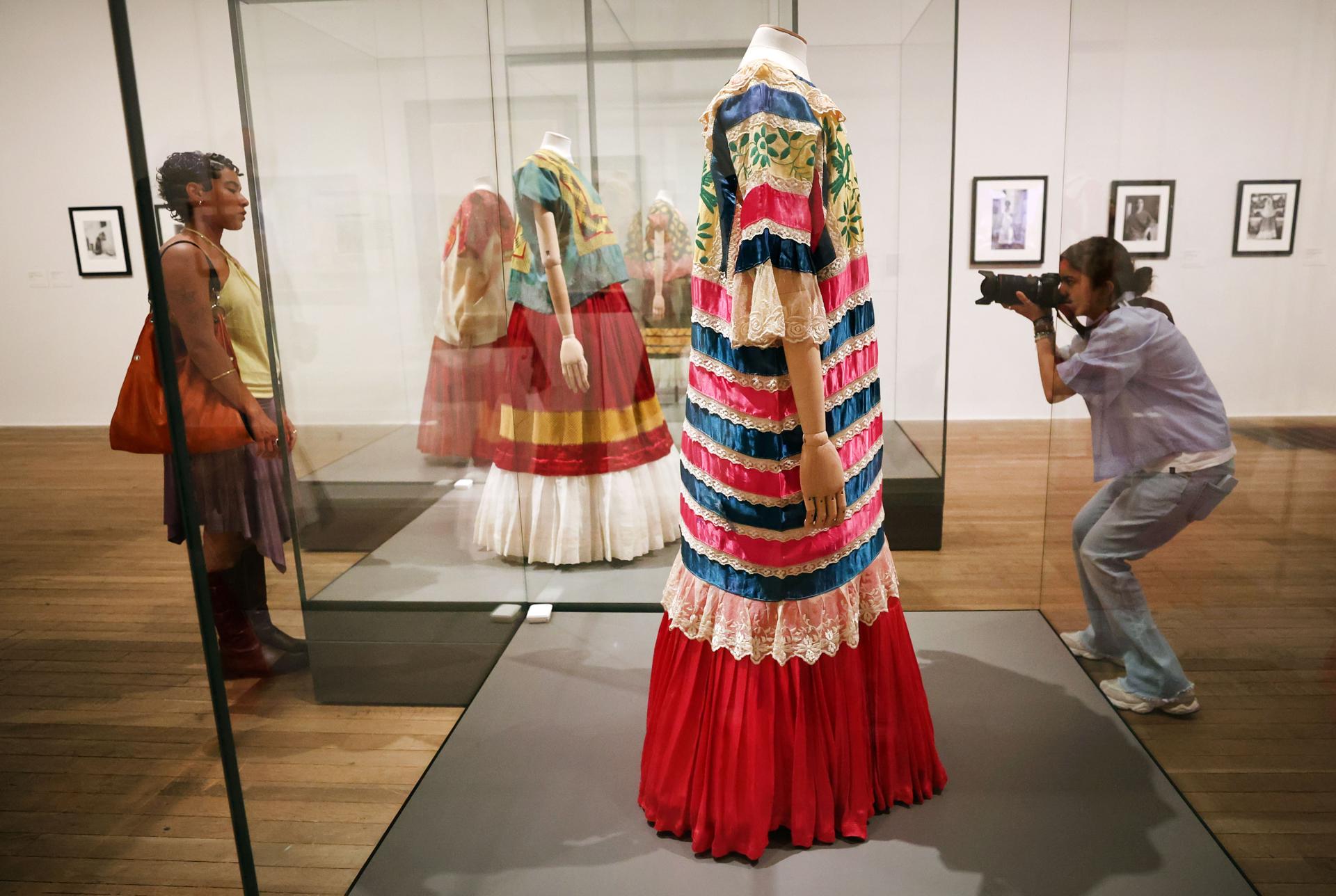 Un empleado del museo Tate Modern de Londres observa vestidos de Frida Kahlo en la exposición 'Frida: La creación de un ícono'. EFE/EPA/ANDY RAIN