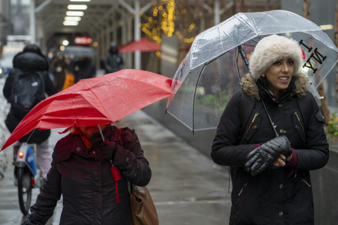 Personas se protegen de la lluvia este lunes, en Nueva York (Estados Unidos). EFE/ Angel Colmenares
