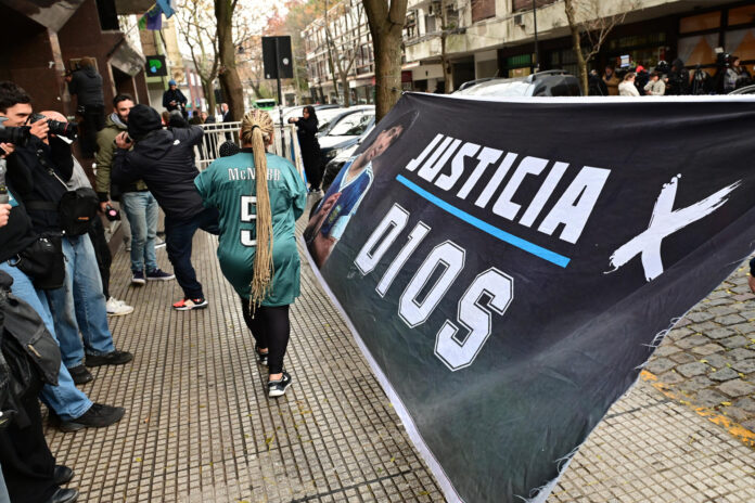 Fotografía de archivo, tomada el pasado 9 de junio, en la que se captó a seguidores del legendario futbolista argentino Diego Armando Maradona, al exigir justicia por la muerte del astro, durante una de las jornadas del juicio, a las afueras de los Tribunales de San Isidro, en Buenos Aires (Argentina). EFE/Matías Campaya
